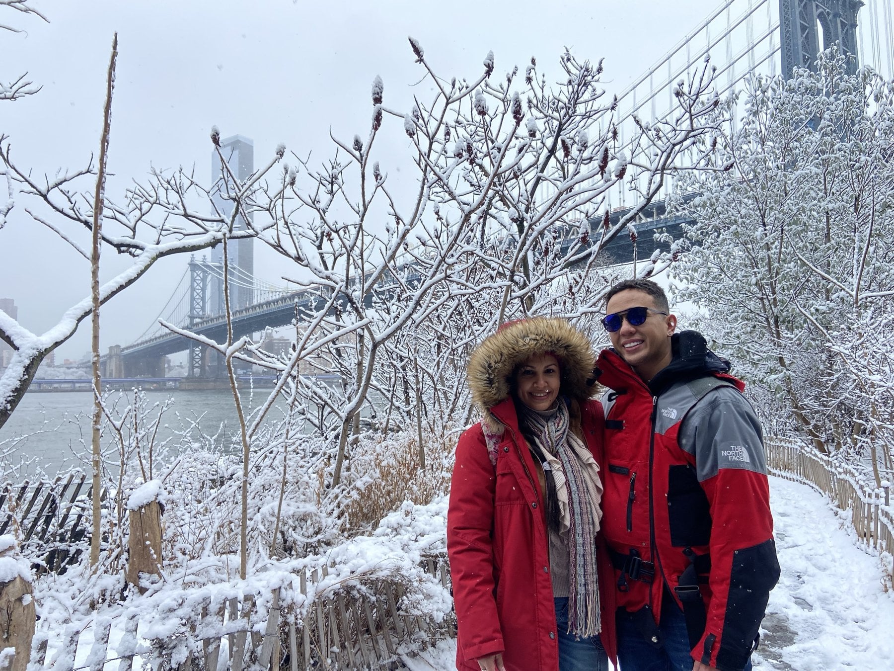 Pareja frente al puente de Manhattan, con nieve