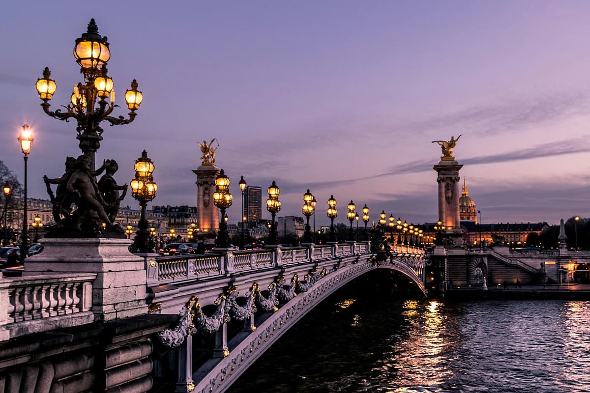 Puente Alejandro III sobre el río Sena en París al anochecer, con sus faroles encendidos
