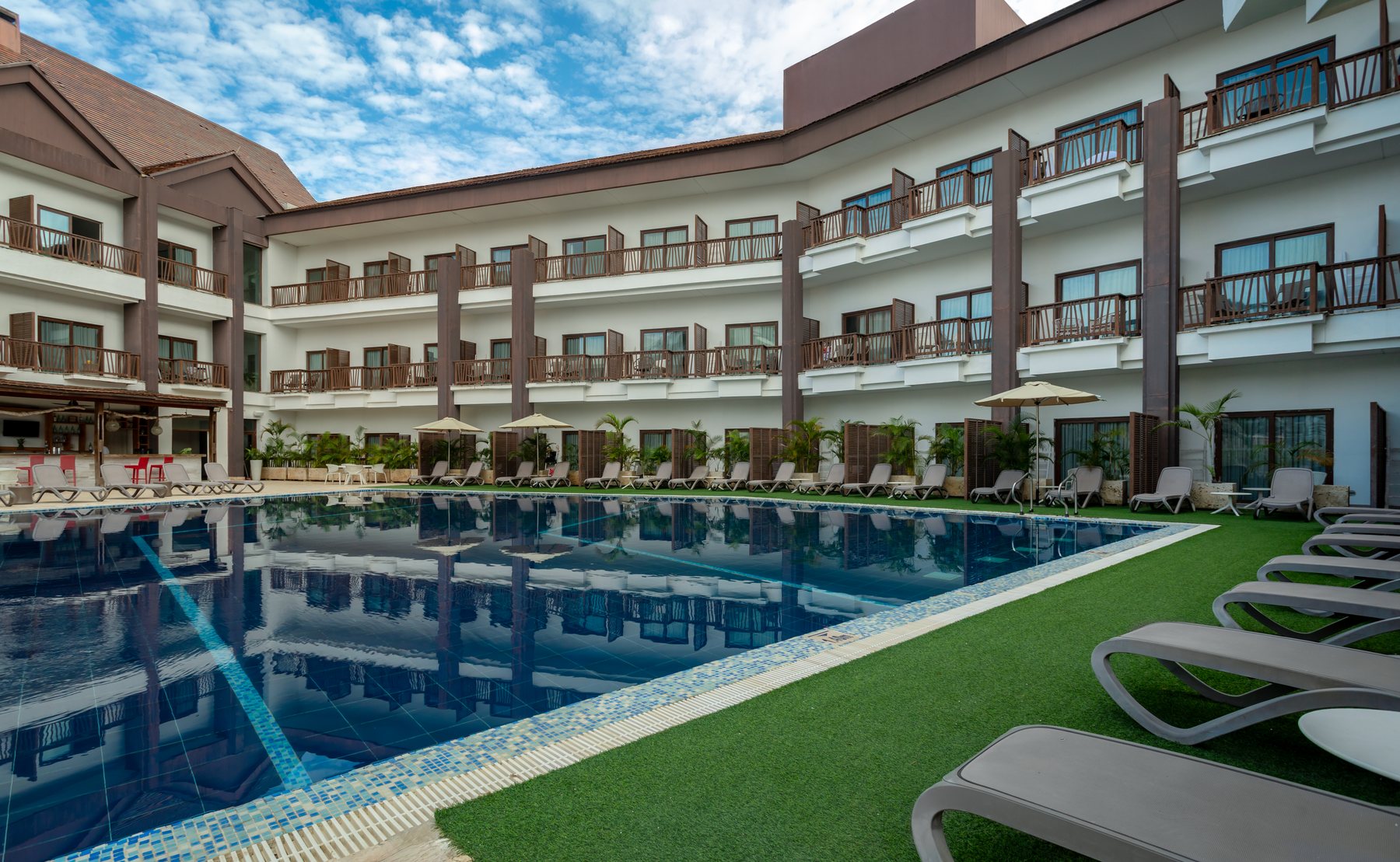 Piscina principal del Grand Sirenis Cartagena con asoleadoras y el edificio del hotel