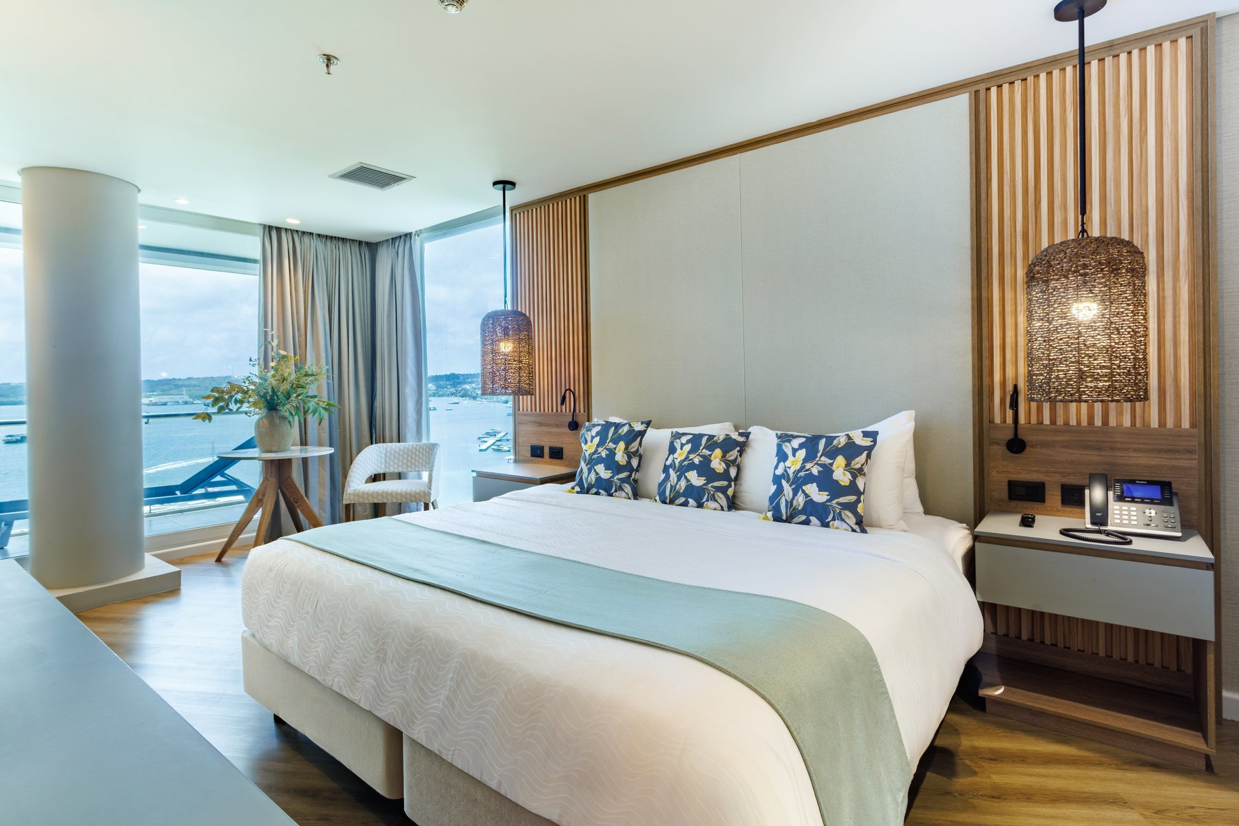 Suite con vista al mar del Grand Sirenis San Andrés, con cama king y ventanal a la bahía
