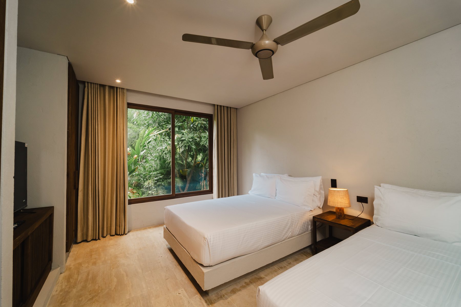 Habitación de Naio con dos camas y ventanal al jardín