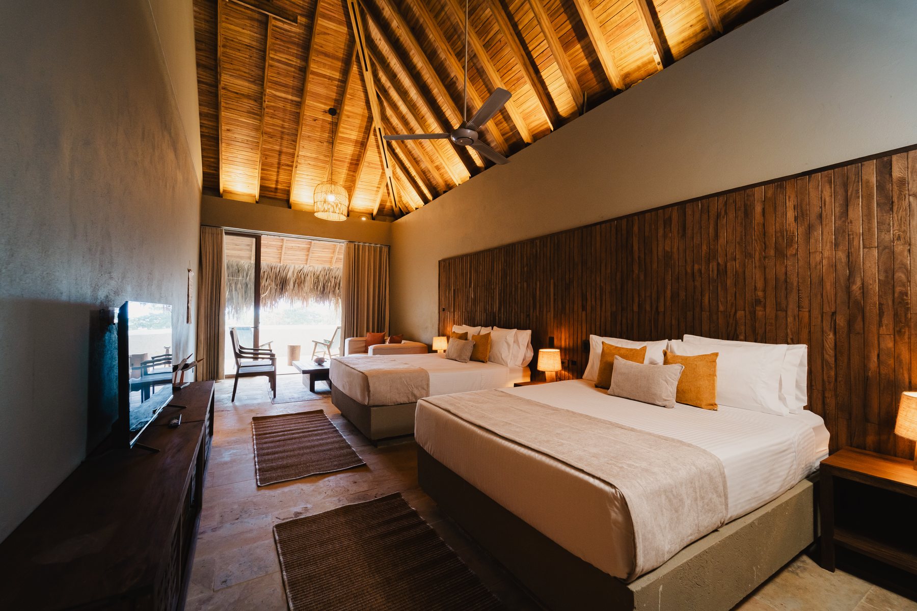 Habitación de Naio con cama king, techo de madera y salida a la terraza