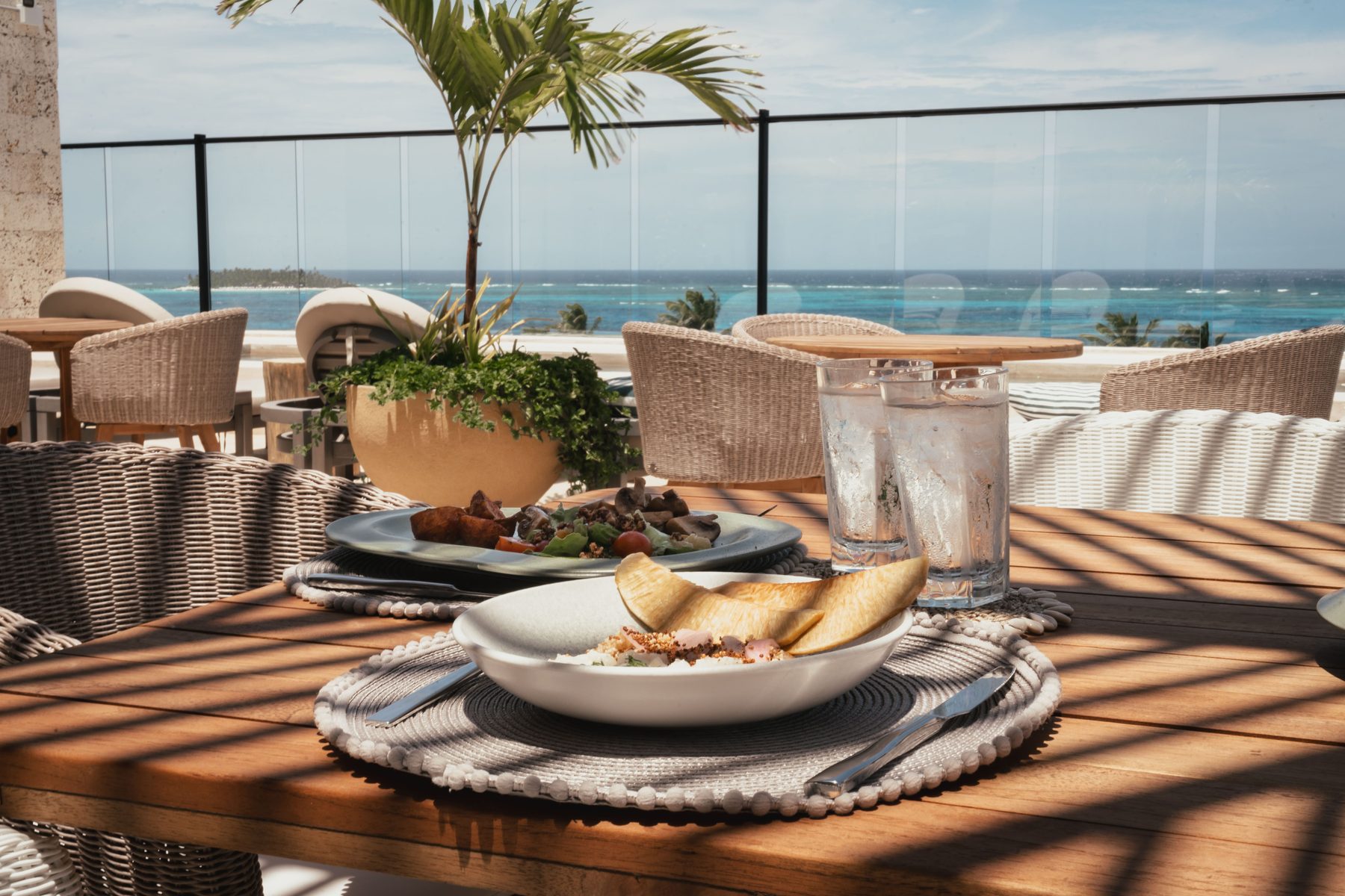 Mesa servida en la terraza del restaurante Wata con el mar de San Andrés al fondo