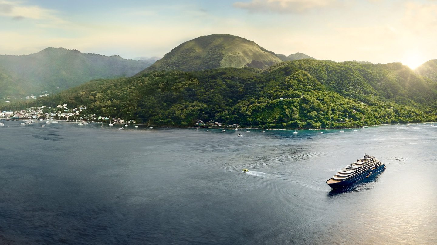 Yate de The Ritz-Carlton Yacht Collection frente a una isla verde